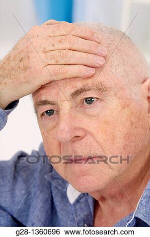 Senior man with one hand on his forehead suffering from a headache View Large Photo Image Stock Photograph - Senior man with one hand on his forehead suffering from a headache. Fotosearch