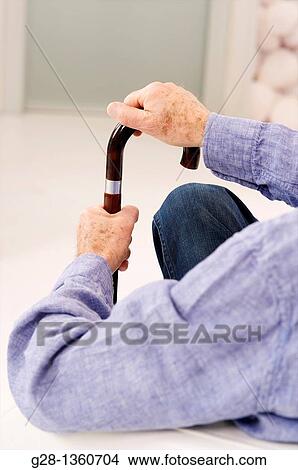 Senior mandetail seen from behind waiting with his hand on a crutch in a clinic waiting room or medical center View Large Photo Image Picture - Senior mandetail seen from behind waiting with his hand on a crutch in a clinic waiting room or medical center. Fotosearch