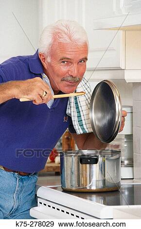 Stock Photo - Senior tasting the sauce. Fotosearch