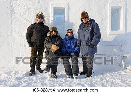 Picture - Senior tourists in front of Snowking castle, Yellowknife, Northwest Territories, Canada. Fotosearch