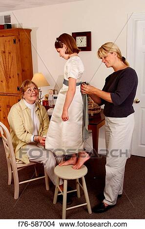 Senior woman and mother sewing and hemming a dress for young girl. View Large Photo Image Picture - Senior woman and mother sewing and hemming a dress for young girl.. Fotosearch