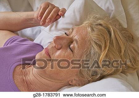 Senior woman asleep on her bed at home View Large Photo Image Stock Image - Senior woman asleep on her bed at home. Fotosearch