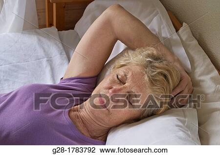 Senior woman asleep on her bed at home View Large Photo Image Stock Image - Senior woman asleep on her bed at home. Fotosearch