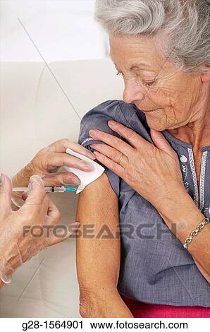 Senior woman being vaccinated against the flue View Large Photo Image Stock Image - Senior woman being vaccinated against the flue. Fotosearch