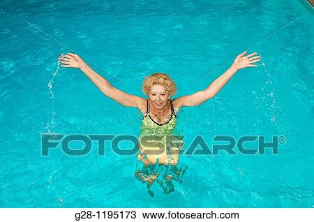 senior woman doing aquagym in a swimming pool View Large Photo Image Stock Image - senior woman doing aquagym in a swimming pool. Fotosearch