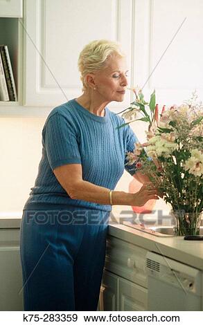 Senior woman enjoying her bouquet of flowers View Large Photo Image Stock Photo - Senior woman enjoying her bouquet of flowers. Fotosearch