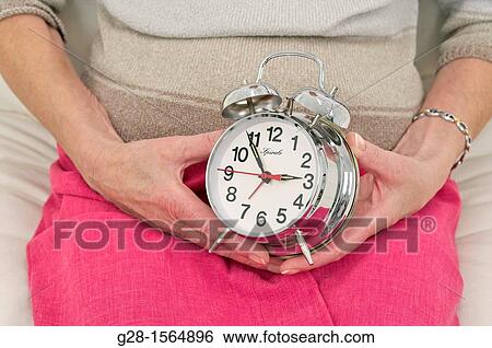 Senior woman? hands holding an alarm clock View Large Photo Image Stock Photograph - Senior woman? hands holding an alarm clock. Fotosearch