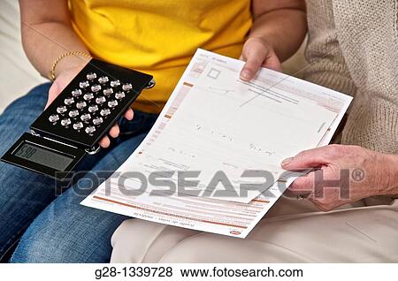 senior woman hands with medical papers with a young woman hands detail counting with a mini calculator and holding medical papers View Large Photo Image Stock Photo - senior woman hands with medical papers with a young woman hands detail counting with a mini calculator and holding medical papers. Fotosearch