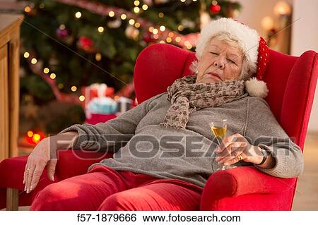 Stock Photograph - Senior woman having a catnap at Christmas time. Fotosearch
