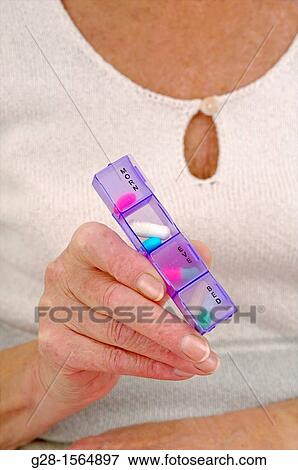 Senior woman holding a pill-box with tablets for her day treatment View Large Photo Image Stock Photo - Senior woman holding a pill-box with tablets for her day treatment. Fotosearch