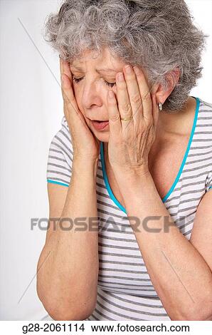 Senior woman holding her face in her hands, feeling, dizzy, or tired, or sad, suffering from depression View Large Photo Image Picture - Senior woman holding her face in her hands, feeling, dizzy, or tired, or sad, suffering from depression. Fotosearch