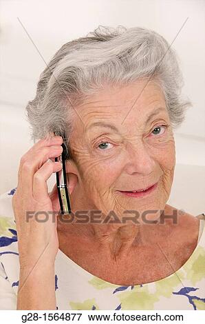 Stock Photo - Senior woman holding her phone and smiling. Fotosearch