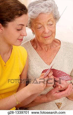 senior woman in beige playing cards with a young woman in yellow View Large Photo Image Stock Image - senior woman in beige playing cards with a young woman in yellow. Fotosearch