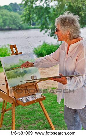 Senior woman painting / watercolors by the side of the Charles River, Cambridge, Massachusetts. USA. View Large Photo Image Stock Photo - Senior woman painting / watercolors by the side of the Charles River, Cambridge, Massachusetts. USA.. Fotosearch