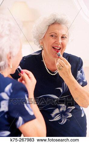 Senior woman putting on lipstick View Large Photo Image Stock Image - Senior woman putting on lipstick. Fotosearch