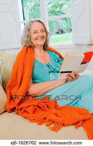 Stock Image - Senior woman reading a book. Fotosearch