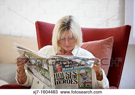 Stock Image - Senior woman reading newspaper. Fotosearch