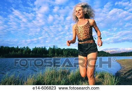 Stock Image - Senior woman running. Six Mile Lake Provincial Park. Alaska. USA. Fotosearch