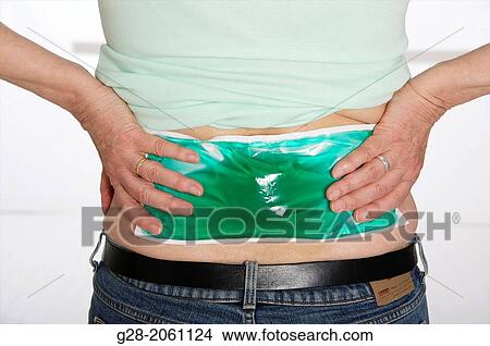 Senior woman? s hands applying a green cold or hot gel compress to relieve pain in her back View Large Photo Image Picture - Senior woman? s hands applying a green cold or hot gel compress to relieve pain in her back. Fotosearch
