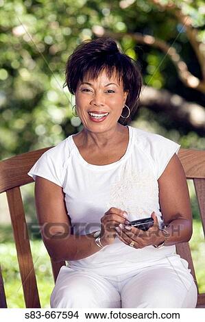 Picture - Senior woman sing a PDA or Blackberry phone. Fotosearch