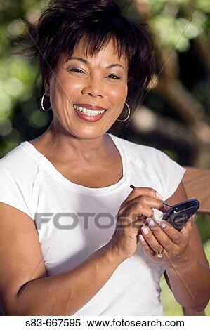 Senior woman sing a PDA or Blackberry phone View Large Photo Image Stock Photography - Senior woman sing a PDA or Blackberry phone. Fotosearch
