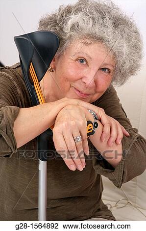 Senior woman smiling and thoughtful resting upon her crutches View Large Photo Image Stock Image - Senior woman smiling and thoughtful resting upon her crutches. Fotosearch