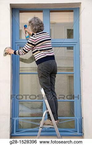 senior woman standing on a step ladder cleaning her windows outside View Large Photo Image Stock Photograph - senior woman standing on a step ladder cleaning her windows outside. Fotosearch