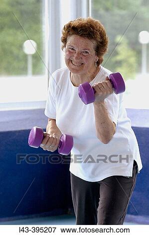 Senior woman using dumbbells View Large Photo Image Stock Photo - Senior woman using dumbbells. Fotosearch