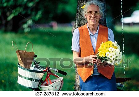 Senior woman with bike in park View Large Photo Image Stock Image - Senior woman with bike in park. Fotosearch