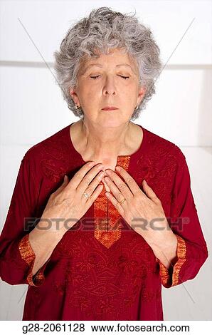 Senior woman with grey hair and eyes shut, applying her two hands on her chest for relief, suffering from asthma View Large Photo Image Stock Photo - Senior woman with grey hair and eyes shut, applying her two hands on her chest for relief, suffering from asthma. Fotosearch