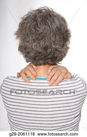 Senior woman with grey hair, holding her neck with her hands, seen from behind, for painful neck or back, backache View Large Photo Image Stock Photo - Senior woman with grey hair, holding her neck with her hands, seen from behind, for painful neck or back, backache. Fotosearch