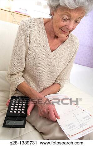 senior woman with medical papers in hand counting with a mini calculator View Large Photo Image Stock Image - senior woman with medical papers in hand counting with a mini calculator. Fotosearch