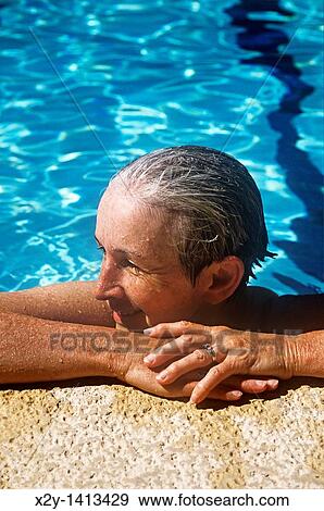Senior women rests after a swim in the pool View Large Photo Image Stock Photo - Senior women rests after a swim in the pool. Fotosearch