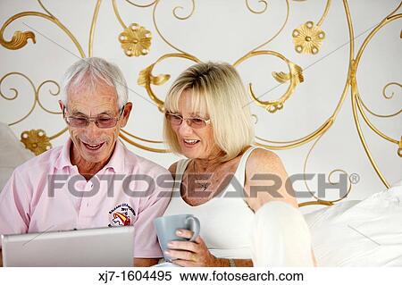 Seniors on bed using laptop computer View Large Photo Image Stock Photography - Seniors on bed using laptop computer. Fotosearch