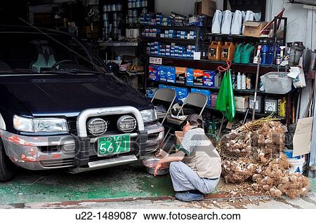 Seoul (South Korea): a mechanic working on a car, surrounded by garlic, in the Sea Gum Jung neighborhood View Large Photo Image Stock Photo - Seoul (South Korea): a mechanic working on a car, surrounded by garlic, in the Sea Gum Jung neighborhood. Fotosearch