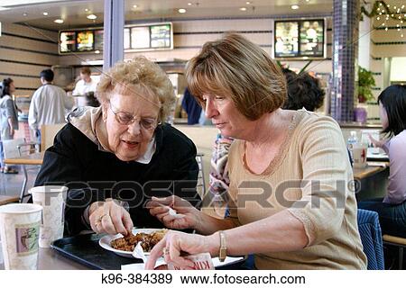Seriors sharing a meal View Large Photo Image Stock Photo - Seriors sharing a meal. Fotosearch