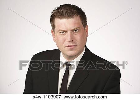 Stock Photo - Serious midadult man wearing black suit and tie. Fotosearch