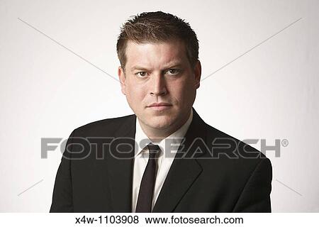 Stock Photo - Serious midadult man wearing black suit and tie. Fotosearch