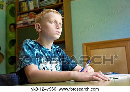 Serious Teenage Boy Sitting at Home Desk and Learning View Large Photo Image Stock Photograph - Serious Teenage Boy Sitting at Home Desk and Learning. Fotosearch