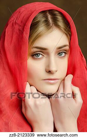 Stock Photo - Serious young woman covered with a red scarf.. Fotosearch
