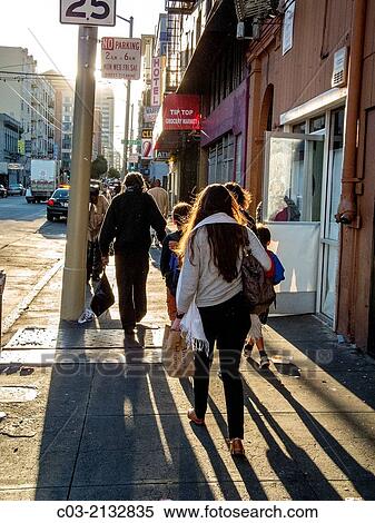 Stock Photography - Setting sun shines on the sidewalk in the high crime Tenderloin district in San Francisco. Note shabby buildings.. Fotosearch
