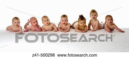 Stock Photo - Seven babies lying on their bellies. Fotosearch