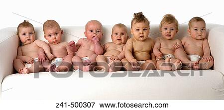 Stock Photo - Seven babies sitting on a bench. Fotosearch