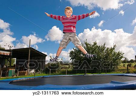 Seven year old boy jumping on a trampoline in the Uk View Large Photo Image Stock Image - Seven year old boy jumping on a trampoline in the Uk. Fotosearch