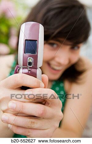 Stock Photo - Seventeen year old girl taking pictures with a mobile phone.. Fotosearch