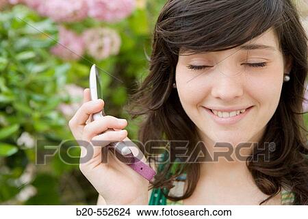 Picture - Seventeen year old girl using mobile phone.. Fotosearch