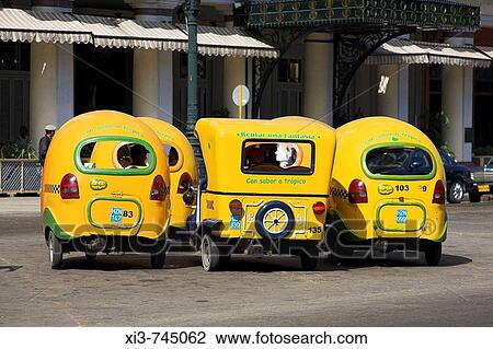 Several yellow three wheeled taxis parked at a taxi rank, Havana, Cuba View Large Photo Image Stock Image - Several yellow three wheeled taxis parked at a taxi rank, Havana, Cuba. Fotosearch