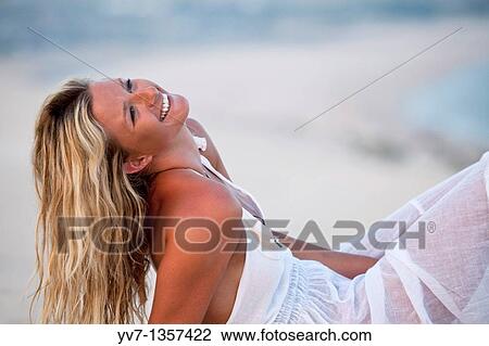 Stock Image - Sexy blonde woman lying on the beach. Fotosearch