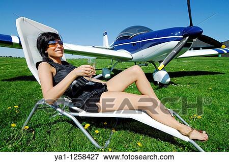 Sexy girl drinking Champagne glassin deckchair by a microlight plane Zenair 601, Belgium View Large Photo Image Stock Photo - Sexy girl drinking Champagne glassin deckchair by a microlight plane Zenair 601, Belgium. Fotosearch