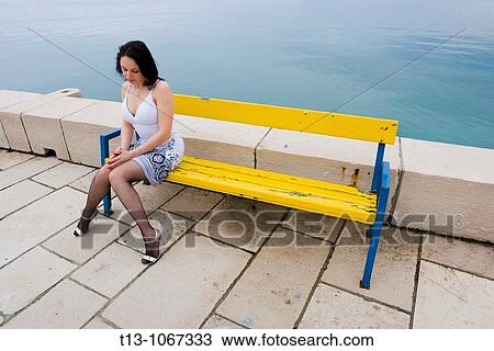 Sexy woman is sitting on a Yellow wooden bench View Large Photo Image Stock Image - Sexy woman is sitting on a Yellow wooden bench. Fotosearch